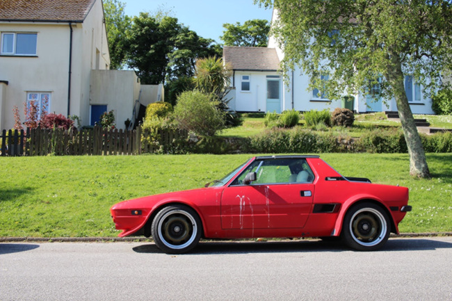 A red sports car on a council estate.