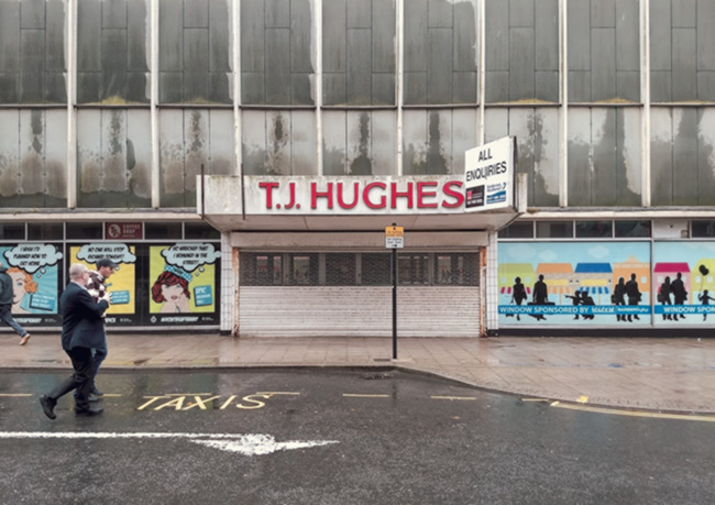 Abandoned retail unit streaked with rain.