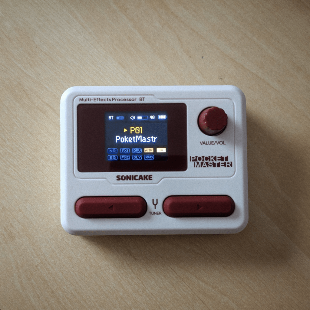A tiny little gadget with a little colour screen, two buttons, and a dial. The colour scheme, off-White and maroon, is an homage to the Famicom, I think.
