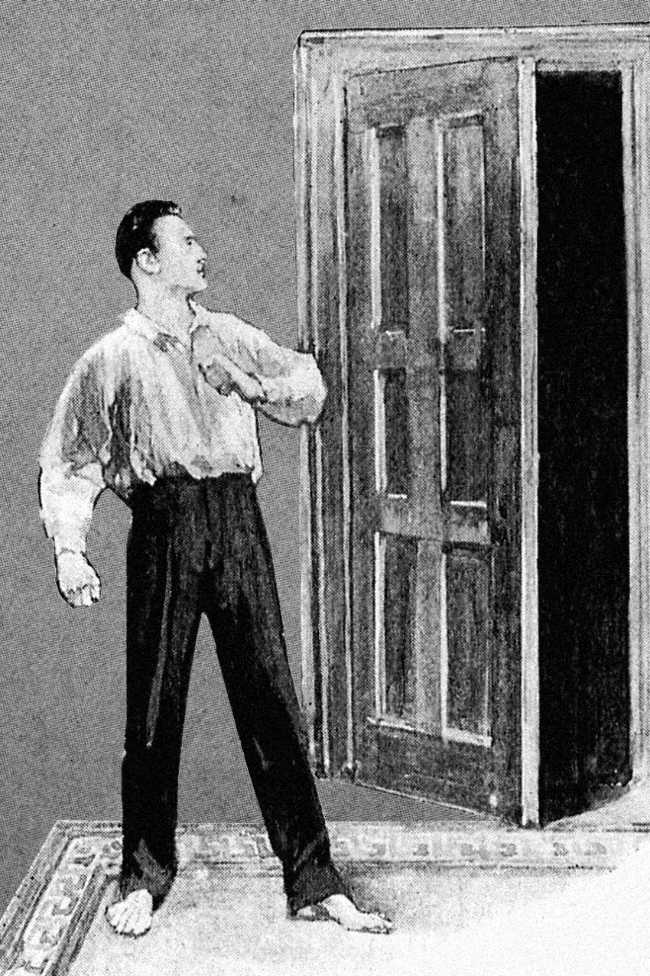 An Edwardian style illustration: a man stands on guard next to an open door beyond which is darkness.