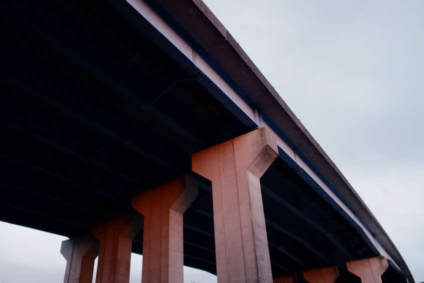 A massive motorway flyover with concrete pillars.
