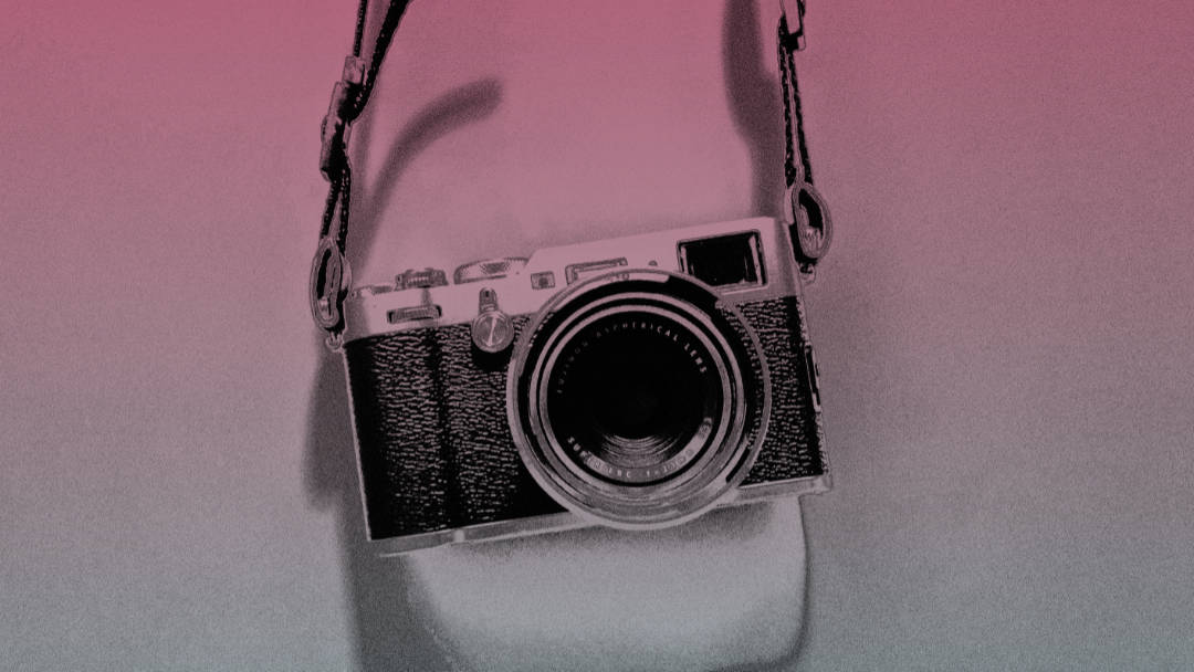 A somewhat fancy camera dangling on its strap.