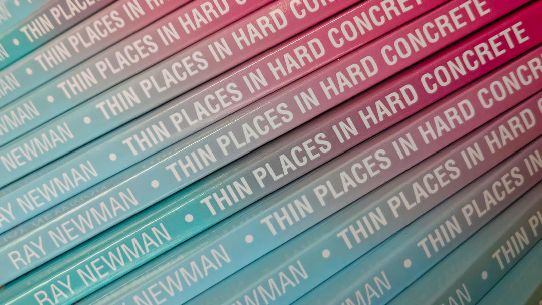 A pile of copies of Thin Places in Hard Concrete with their spines forming a rippling staircase.