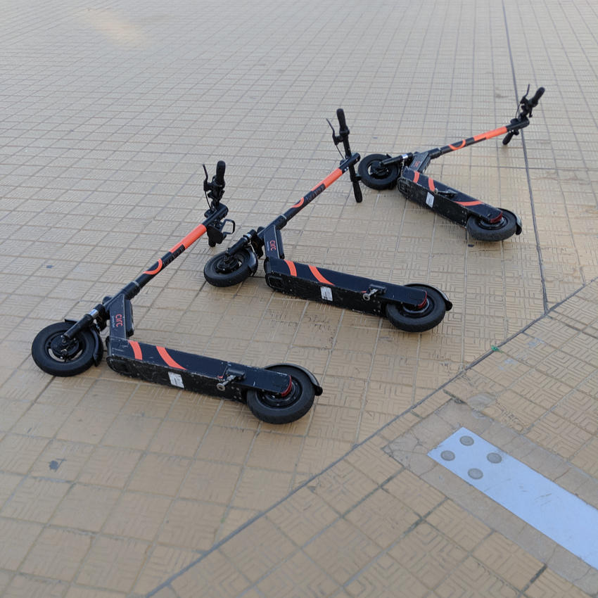 E-scooters scattered on a pavement.