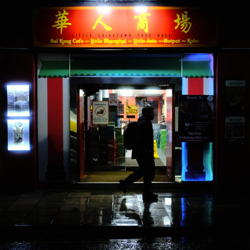 Chinatown in Bristol with glowing signs and wet pavements.